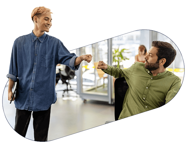Two workers in modern office bump fists